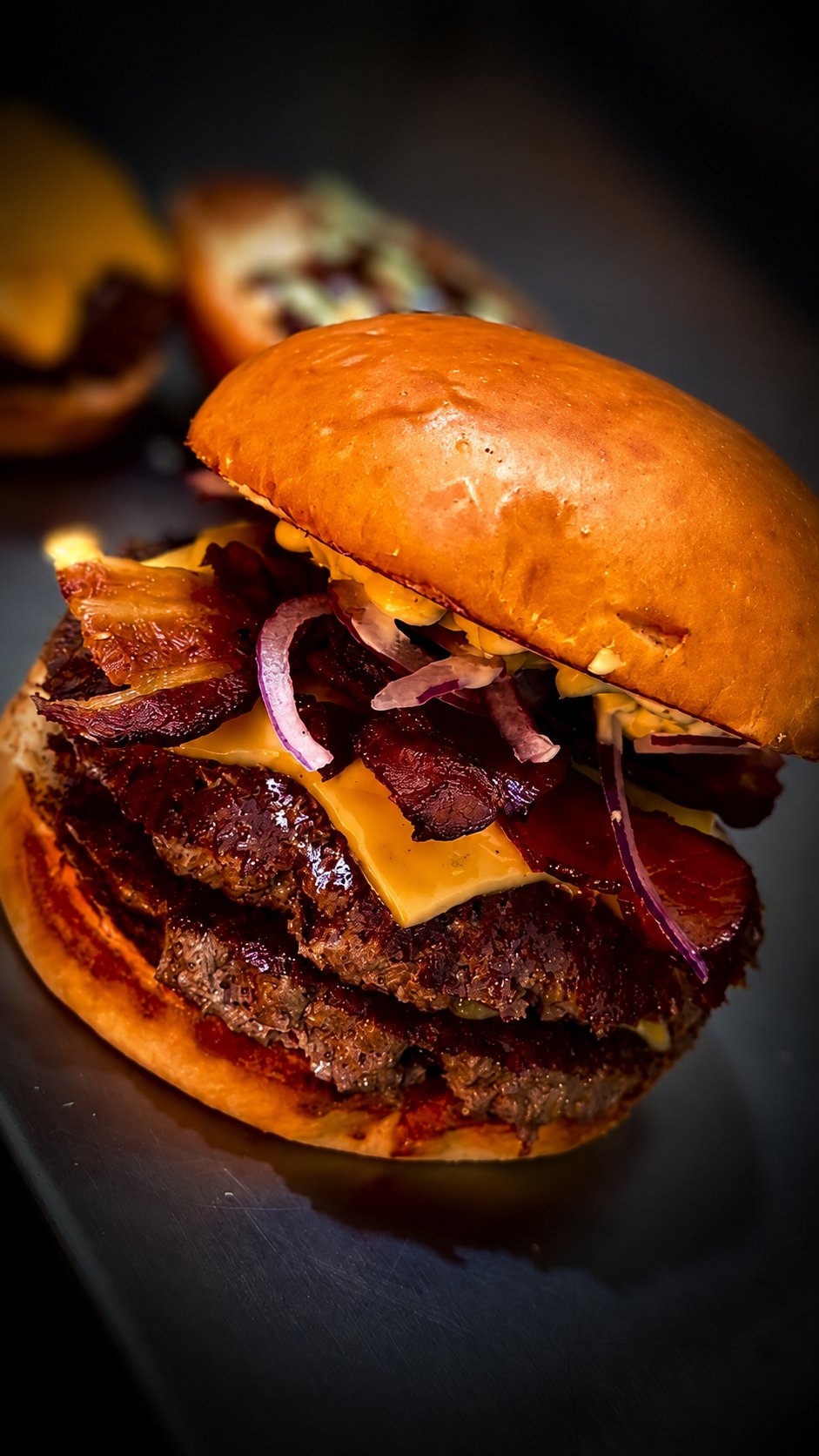 Duplo Cheddar — dois hambúrgueres com cheddar derretido, bacon e cebola roxa